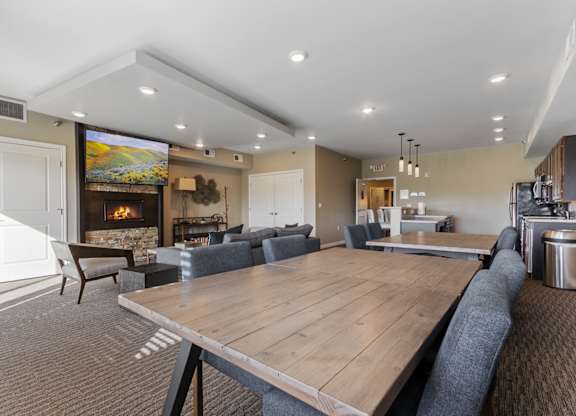 A modern dining room with a large wooden table and grey chairs.
