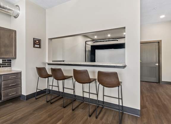 Three brown leather bar stools are placed in front of a mirror.
