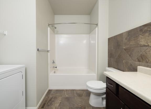 A white toilet sits next to a bathtub in a bathroom.