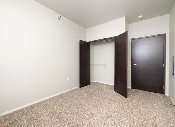 A room with a carpeted floor and a black door.