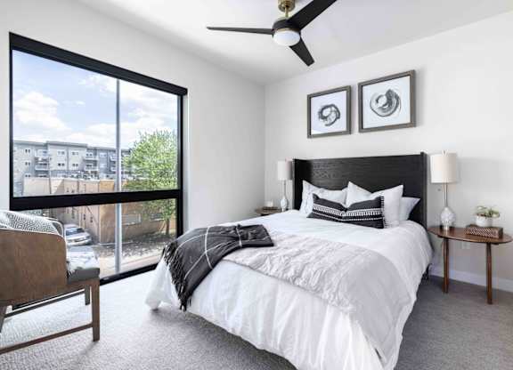 A bedroom with a large bed and a ceiling fan.