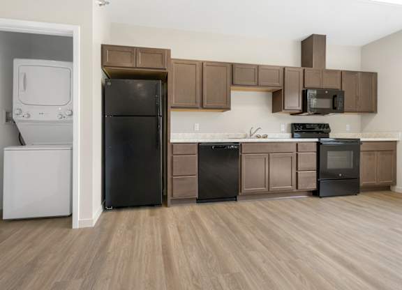 A kitchen with brown cabinets and black appliances.