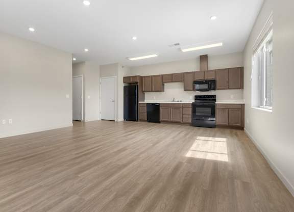 A spacious kitchen with wooden floors and modern appliances.