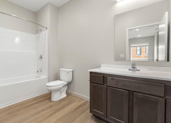 A white toilet sits in a bathroom next to a sink.