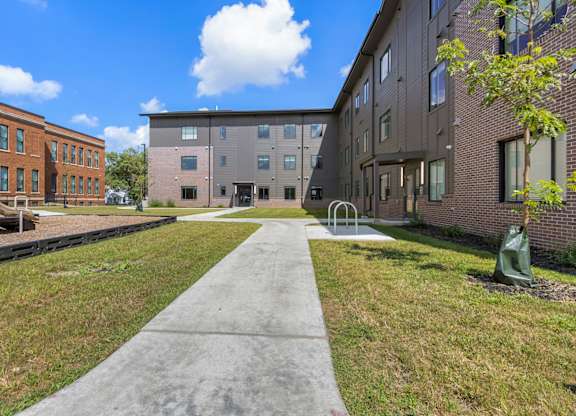 A concrete walkway leads between two buildings.