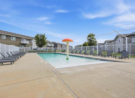A swimming pool with a green pole and a red umbrella in the middle of it.