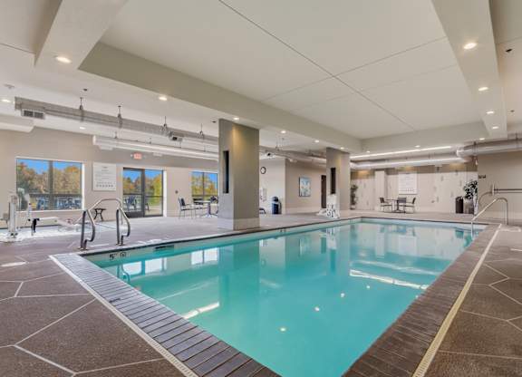 A large indoor swimming pool with a tiled floor and walls.
