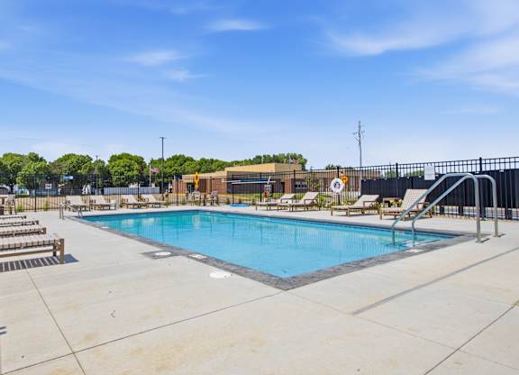 A large outdoor swimming pool with a slide and sun loungers.