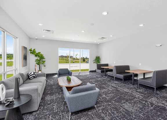 A spacious waiting room with grey couches and a view of the outside.