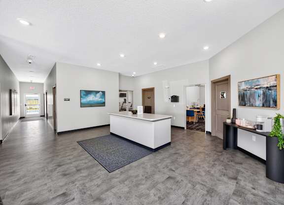 A reception area with a white reception desk and a grey carpet.