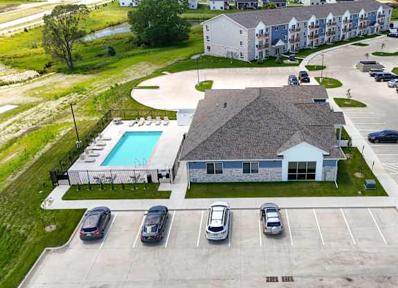 A large white building with a pool in front of it.