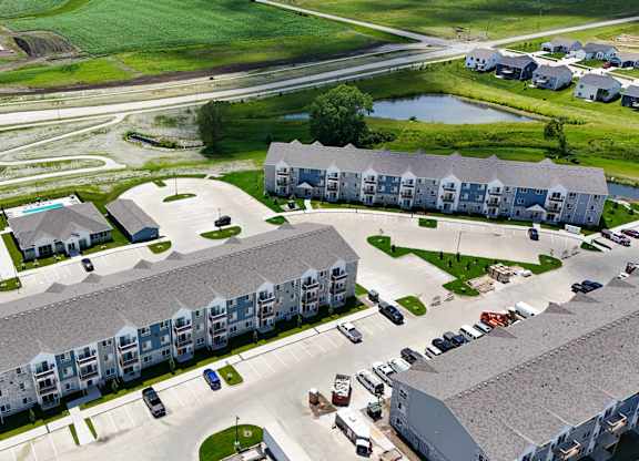 A large apartment complex with a parking lot in front.