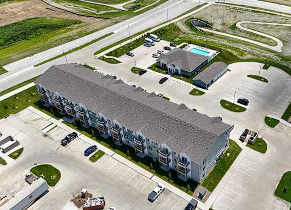 Apartment complex with a swimming pool and a parking lot.