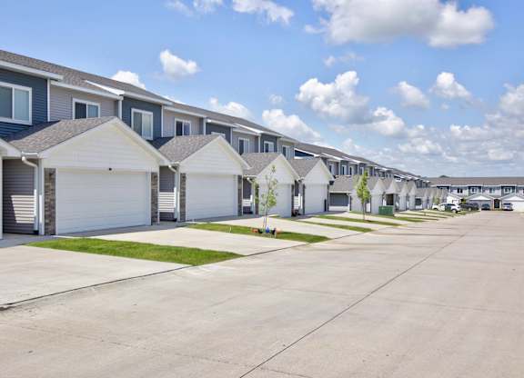 A row of houses with garages and driveways.