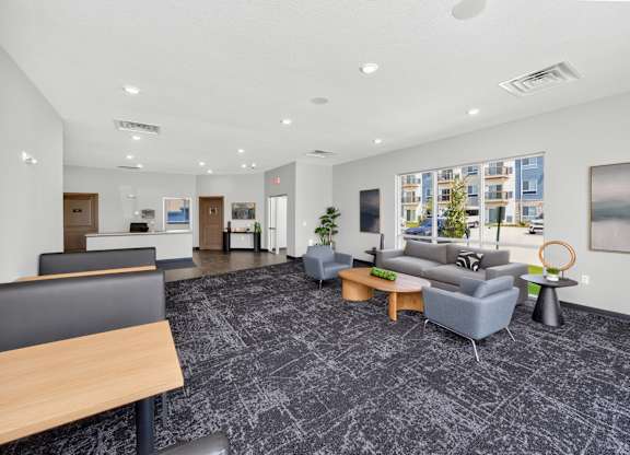 A spacious office lobby with a grey carpet and modern furniture.