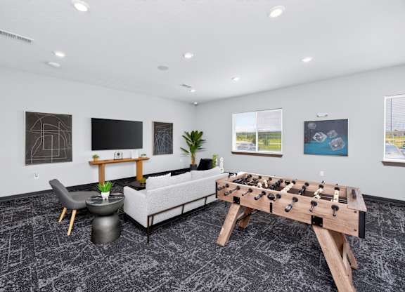 A foosball table is in the middle of a room with a couch, chair, and table.