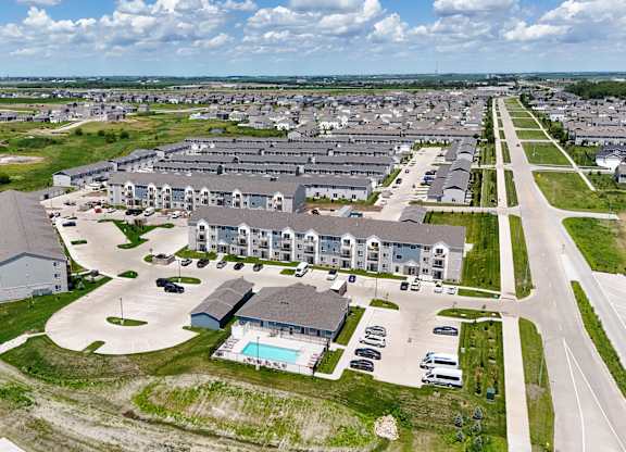 A bird's eye view of a residential area with houses and a swimming pool.