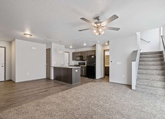 A spacious living room with a staircase on the right side.