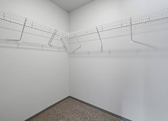 Empty room with wire shelves and carpeted floor.