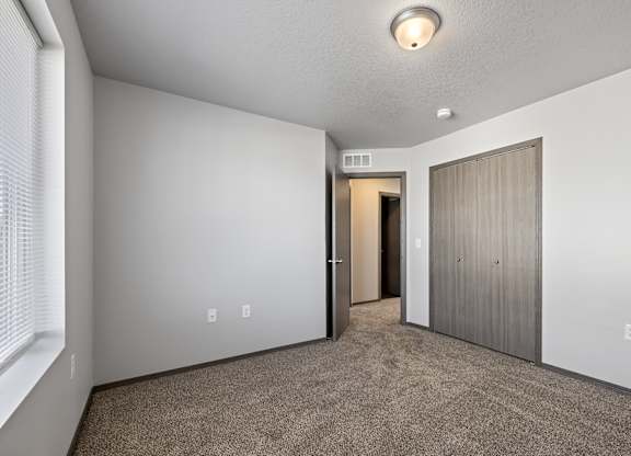 A room with a carpeted floor and a door on the right.
