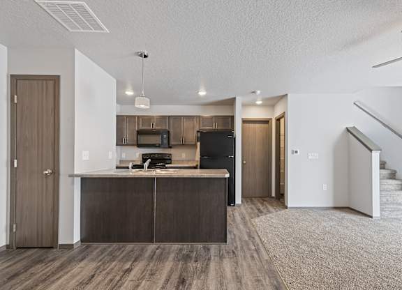 A kitchen with a microwave, oven, and refrigerator.