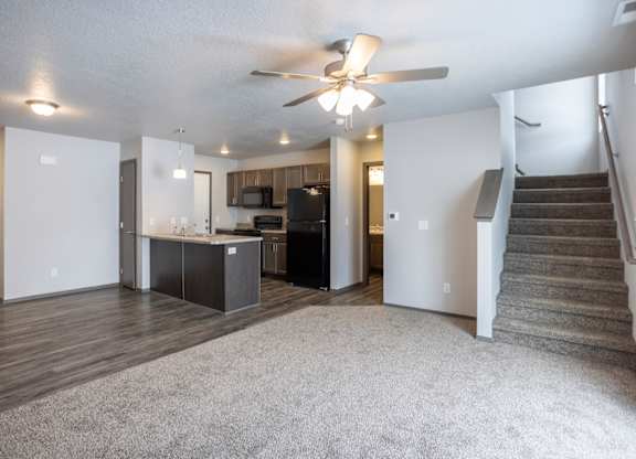 A spacious living room with a staircase leading to the upper floor.