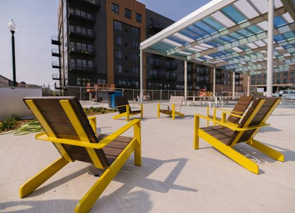 Two yellow chairs are placed on a concrete floor.