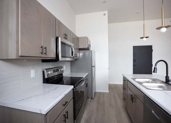 A kitchen with a white counter top and wooden cabinets.