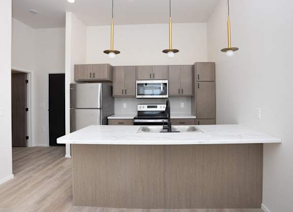 A kitchen with a white counter top and wooden cabinets.