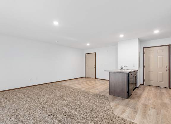 A kitchen area with a sink and cabinets is visible in the image.