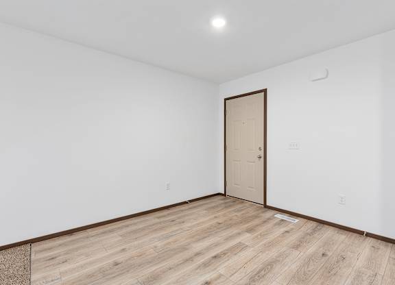 A room with a wooden floor and a door.