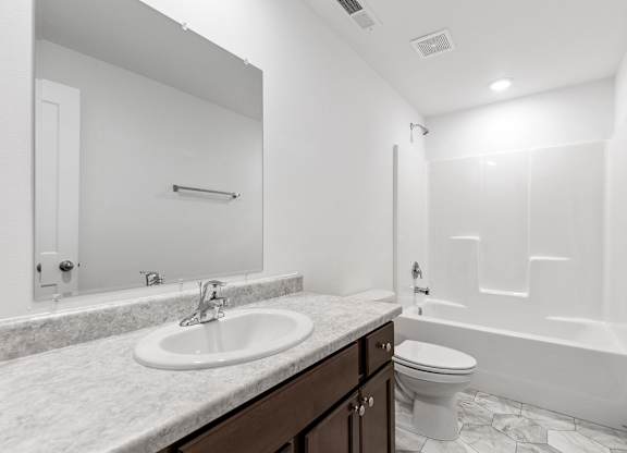 A white bathroom with a sink, toilet, and bathtub.
