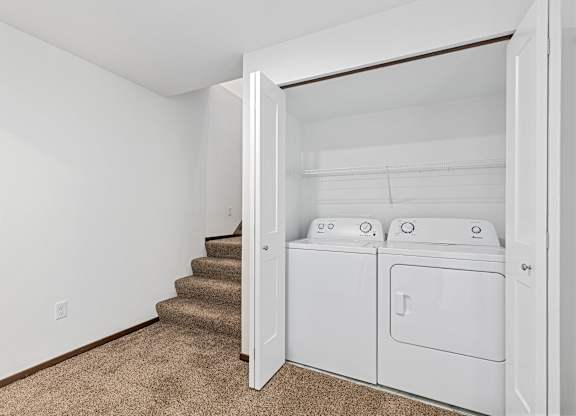 A white laundry room with a washer and dryer.