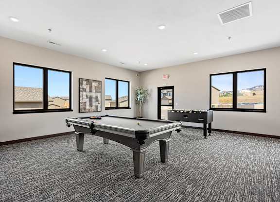 A room with a pool table and a bench.