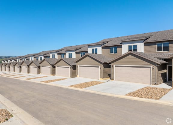 A row of houses with garages in front.