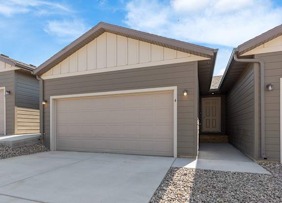 A modern house with a garage door open.
