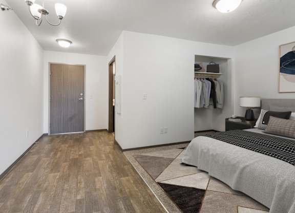 A bedroom with a bed, a wardrobe, and a painting on the wall.