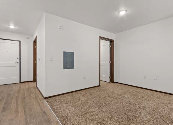 A room with a white wall and a brown carpet.