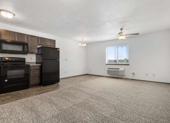 A spacious living room with a carpeted floor and a window.