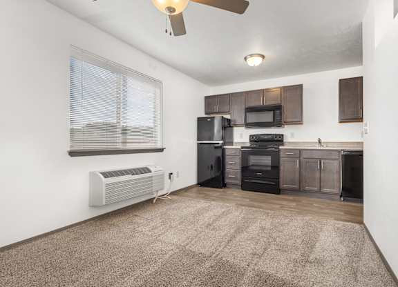 A kitchen with a black stove top oven and microwave.