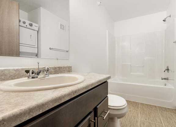 A bathroom with a sink, toilet, and bathtub.