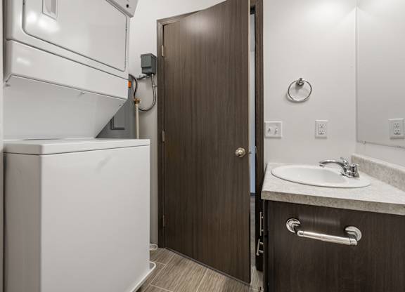 A bathroom with a white toilet and a brown door.