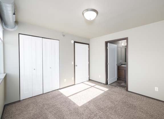 A room with a carpeted floor and a white ceiling with a light fixture.