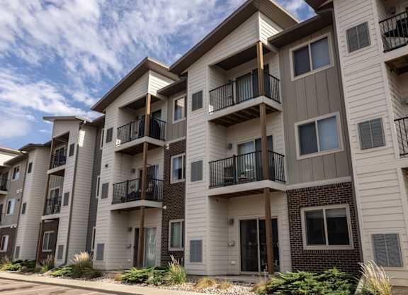 A row of modern apartment buildings with balconies and windows.