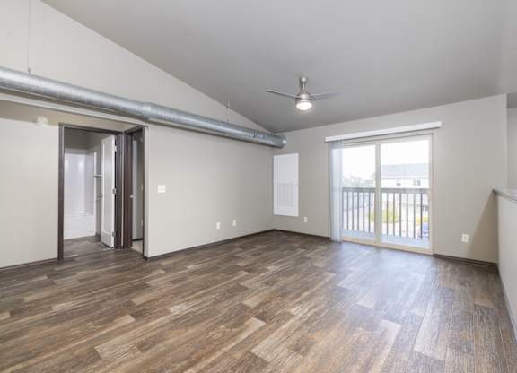 A room with wooden flooring and a ceiling fan.