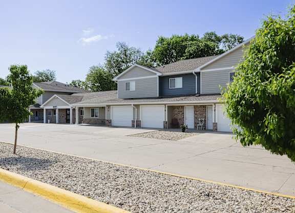 A row of houses with a gravel driveway in front.