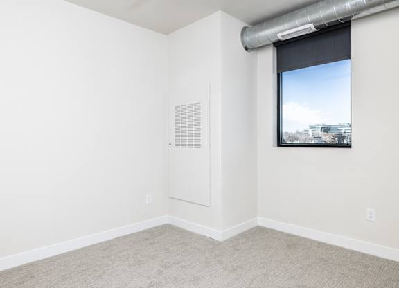 A room with a window and a picture on the wall.