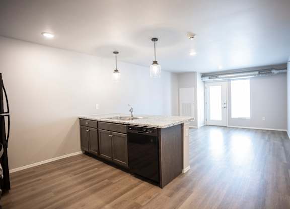 Spacious, combined kitchen and living room with breakfast bar seating.