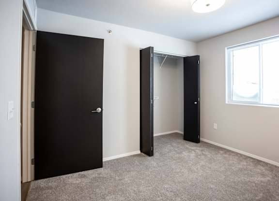 Spacious bedroom with neutral walls and ample natural light.