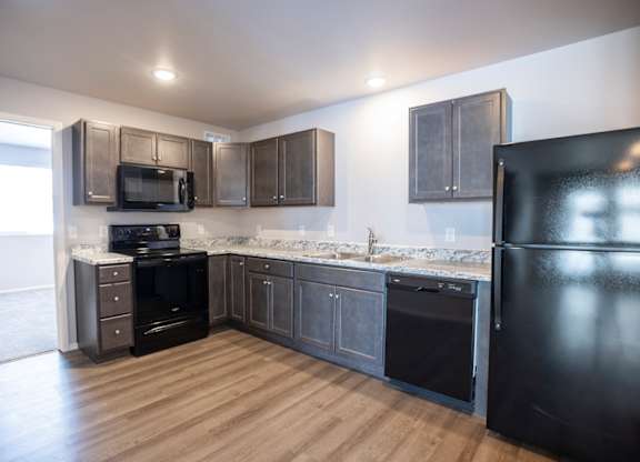 Modern open-concept kitchen and living area with black appliances.